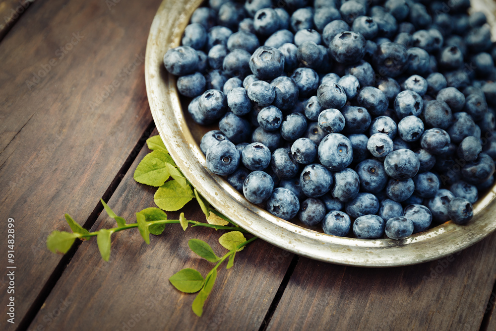 Fresh blueberries crop on a metal plate in garden Fresh blueberries crop on a metal plate in garden
