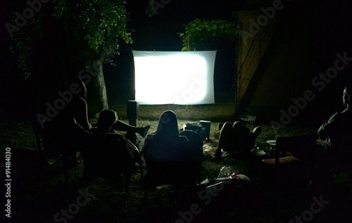 Friends watching movie outside in the yard
