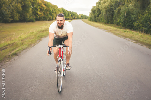 Fototapeta Naklejka Na Ścianę i Meble -  Young bearded hipster driving bicycle