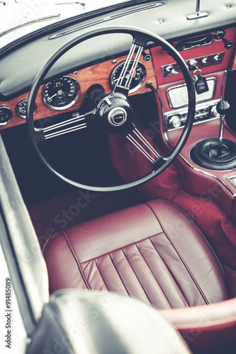 Steering wheel and dashboard in interior of old automobile.