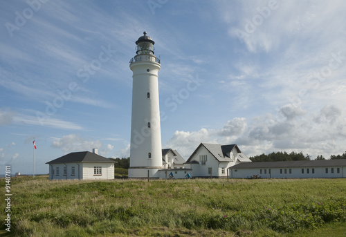 Traditional Danish Lighthouse. A grand majestic lighthouse stand proud and tall and is set off by an excellent cloudscape.