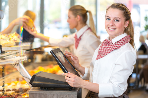 Fotografie Shopkeeper at bakery working at cash register