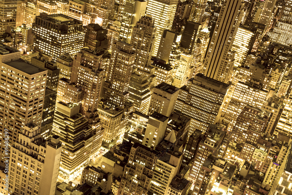 Golden cityscape of New York City buildings and lights at night Golden cityscape of New York City buildings and lights at night
