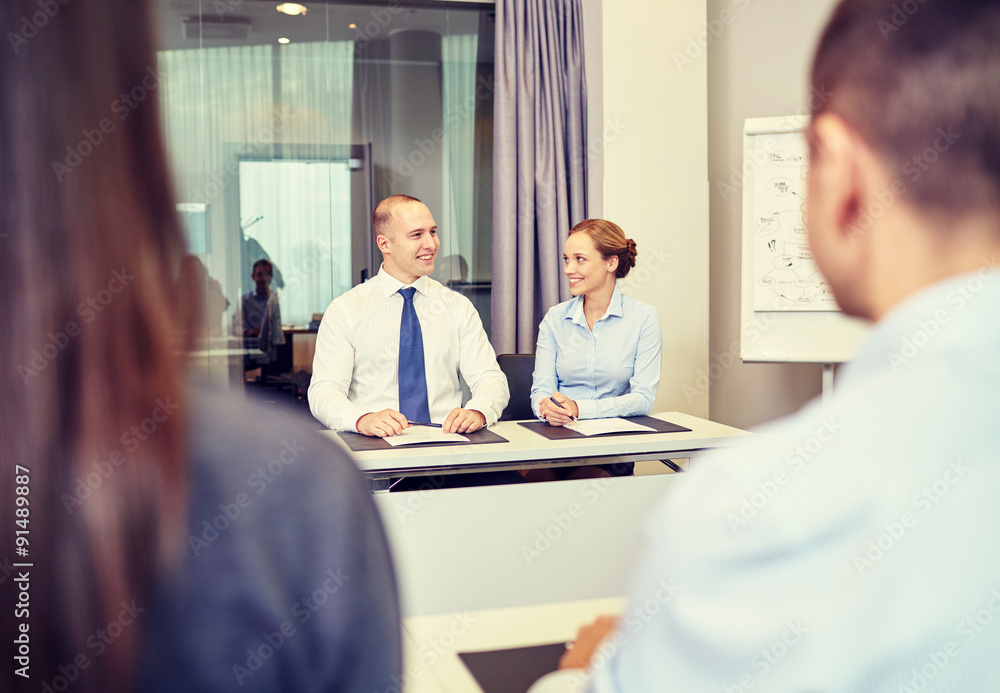 group of smiling businesspeople meeting in office group of smiling businesspeople meeting in office