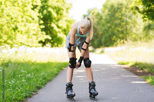 happy young woman in rollerblades riding outdoors