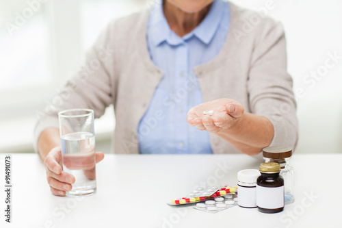 close up of senior woman with water and pills