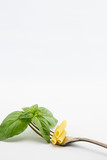Basil leaves on fork, isolated on white background