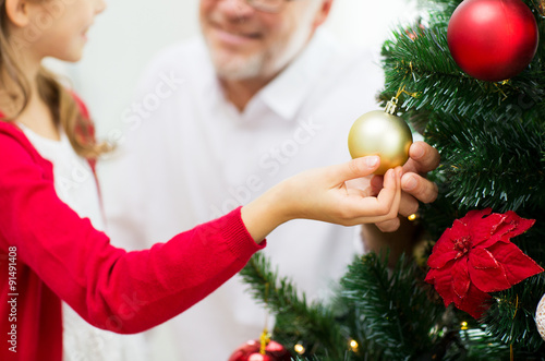 close up of happy family decorating christmas tree