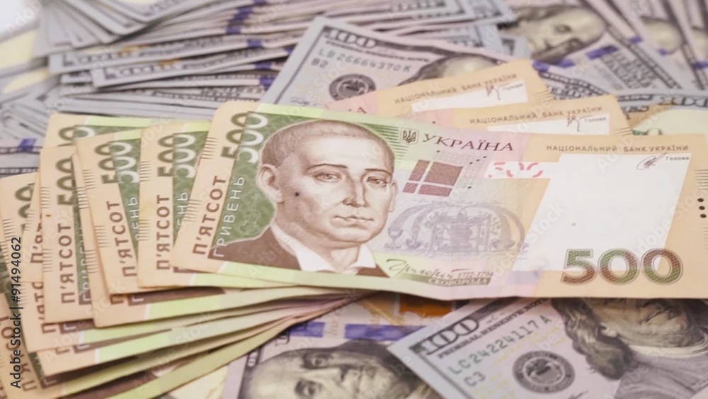monetary unit of Ukraine on the background of hundred-dollar bills monetary unit of Ukraine on the background of hundred-dollar bills
