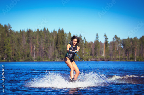 Fototapeta Naklejka Na Ścianę i Meble -  Young woman study riding wakeboarding on a lake