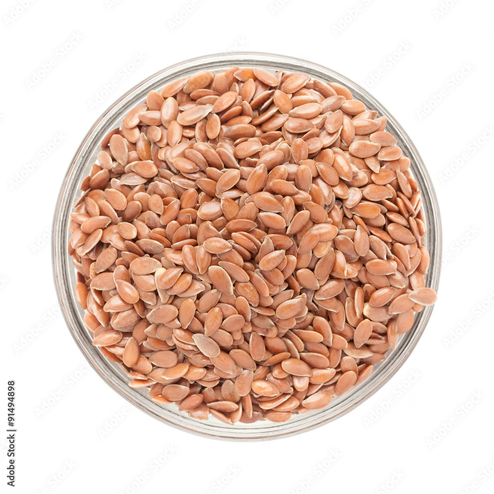 Top view of Organic Linseed or Flaxseed (Linum usitatissimum) in glass bowl isolated on white background.