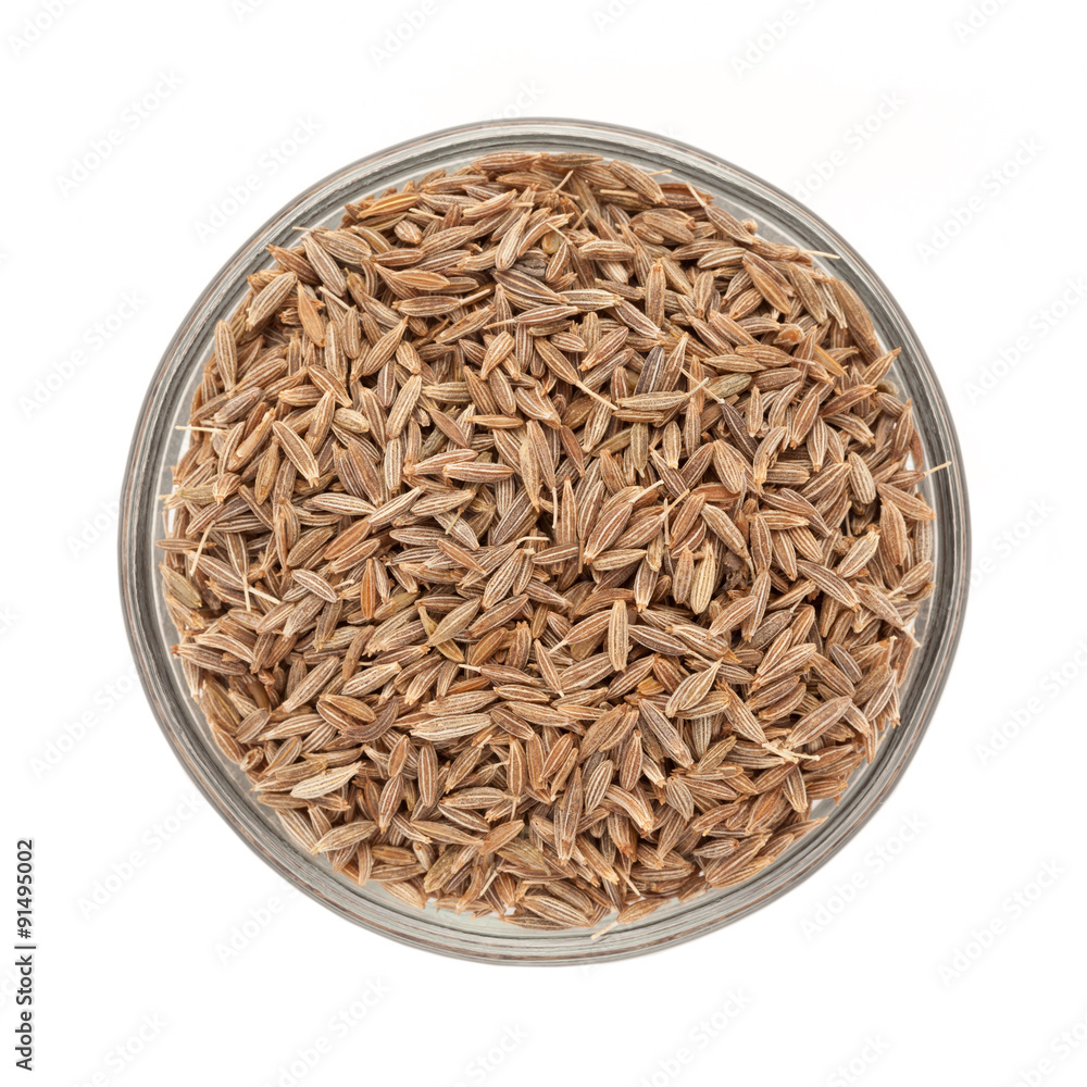 Top view of Organic Cumin seed (Cuminum cyminum) in glass bowl isolated on white background.