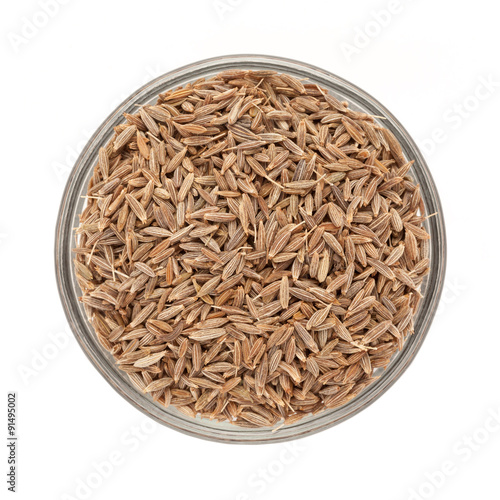Top view of Organic Cumin seed (Cuminum cyminum) in glass bowl isolated on white background.