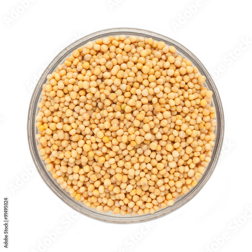 Top view of Organic yellow mustard (Brassica alba) in glass bowl isolated on white background.