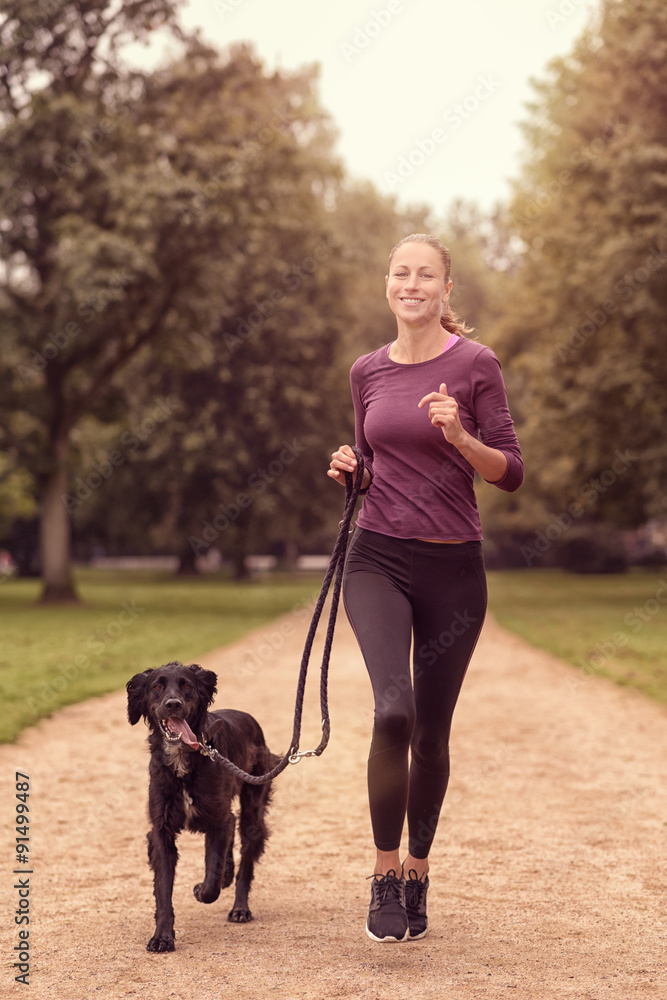 Gesunde Frau joggt mit ihrem Hund Gesunde Frau joggt mit ihrem Hund