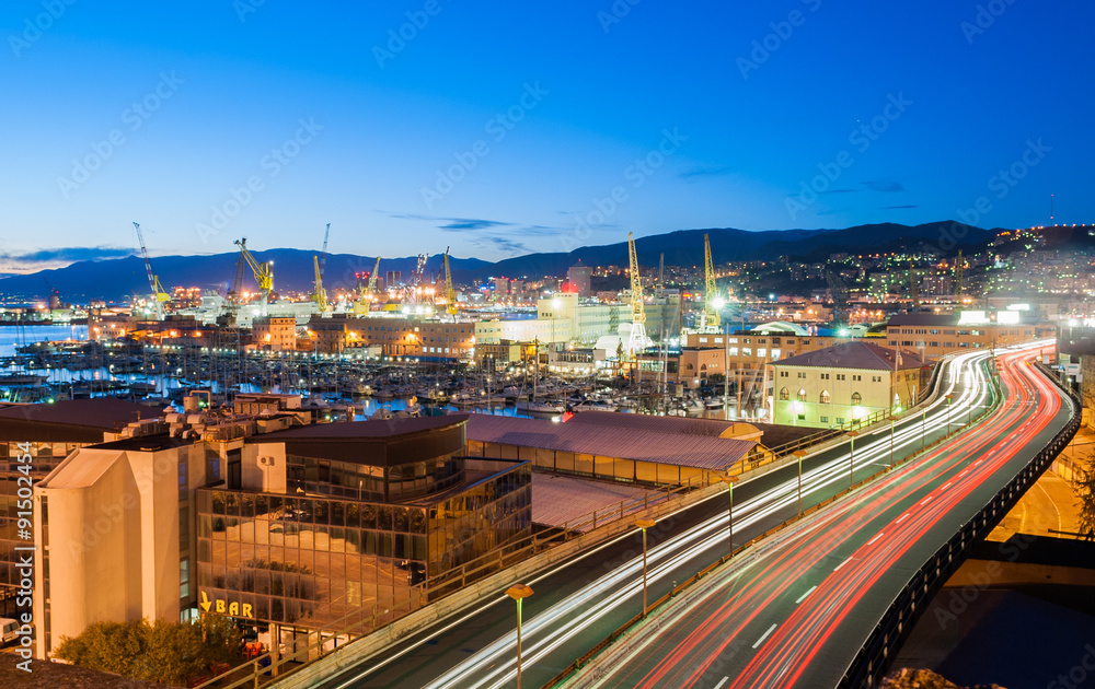 Fototapeta premium Traffic in a street of Genoa during the twilight