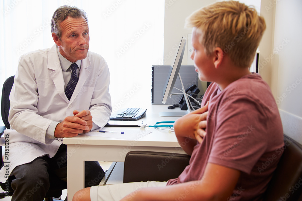 Teenage Boy Having Consultation With Doctor In Office Teenage Boy Having Consultation With Doctor In Office