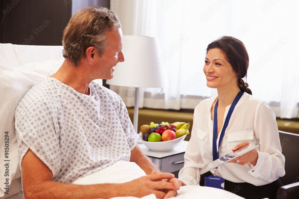 Female Doctor Talking To Male Patient In Hospital Bed Female Doctor Talking To Male Patient In Hospital Bed