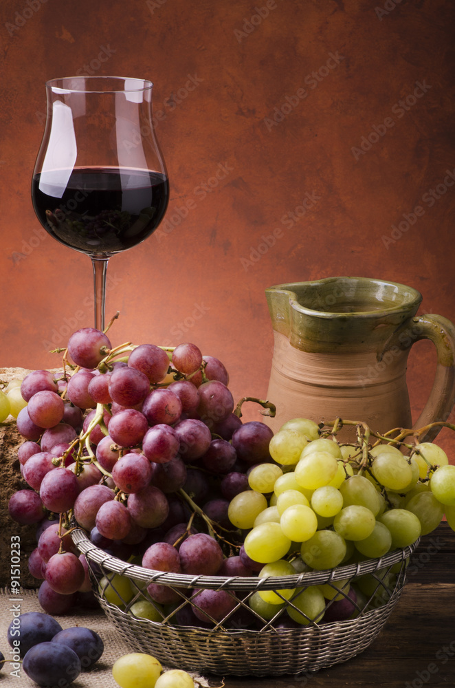 natura morta con calice di vino e cestino di uva