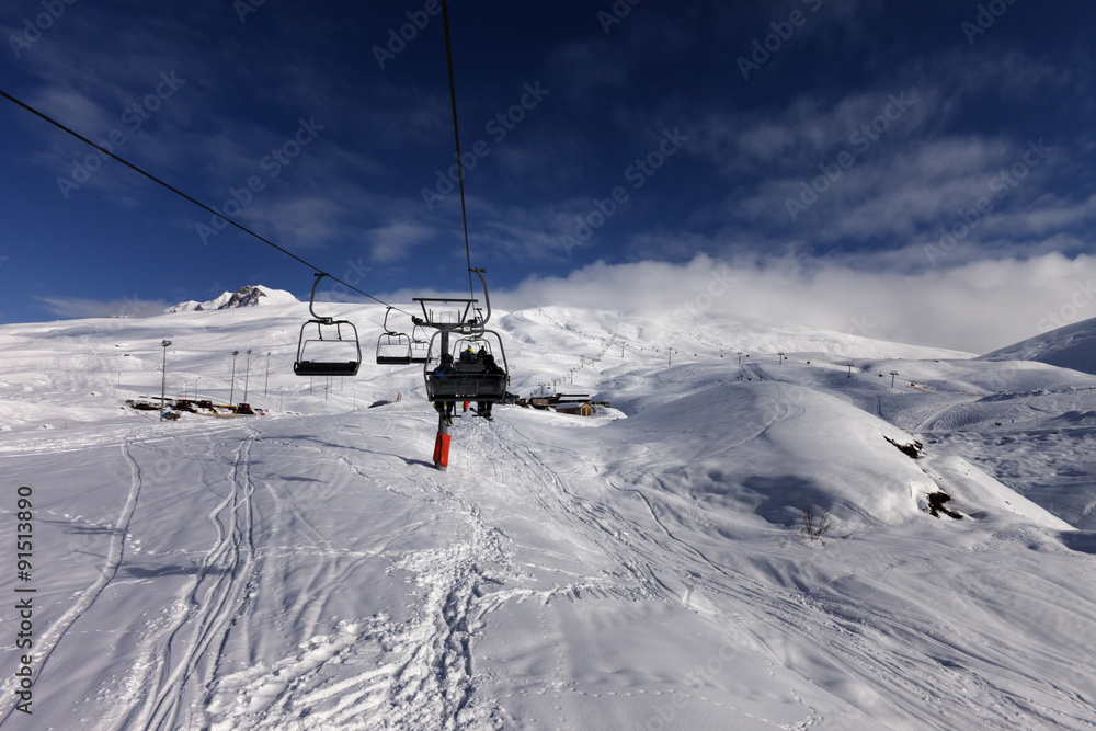 Chair-lift and off-piste slope in sun day Chair-lift and off-piste slope in sun day