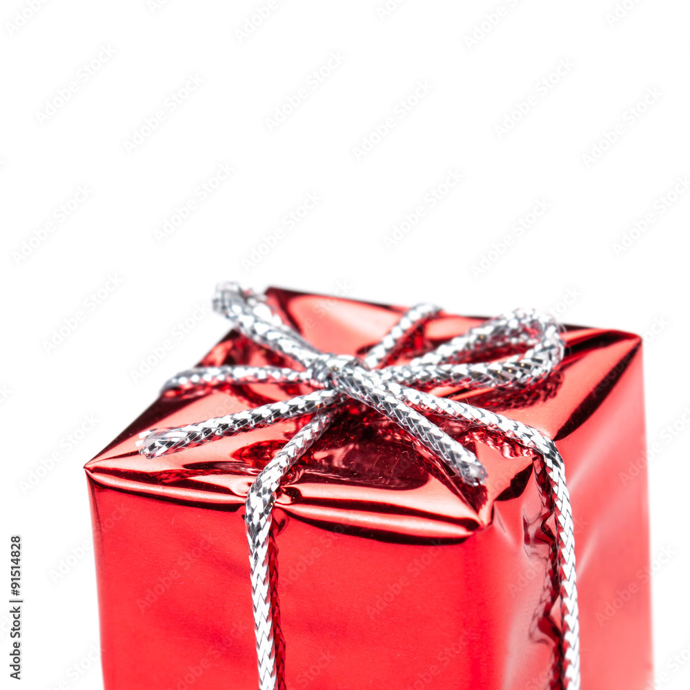 Fototapeta premium Red gift box with silver ribbon and bow isolated on white macro