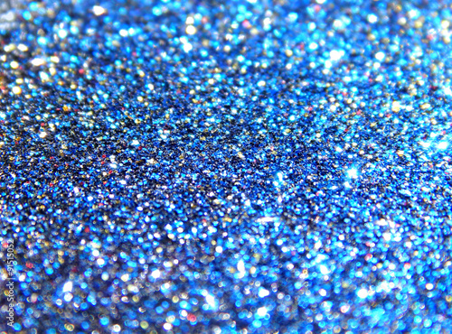 Blurry background of blue, black, golden and red glitter sparkle 