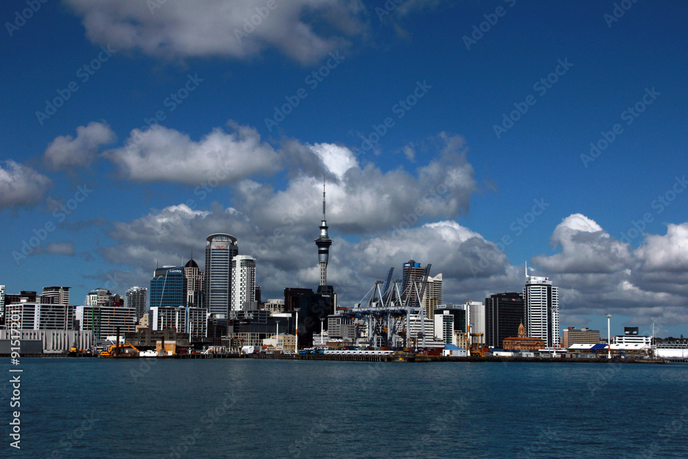 Auckland, New Zealand - the largest and most populous urban area in the country, view of the city from the water on a bright sunny day with cumulus clouds in the sky