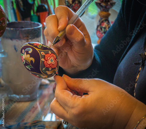 artist painting a wooden egg given as gifts during Orthodox Easter in Russia symbolizing life 