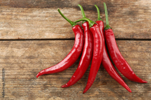 Red hot peppers on wooden table close up