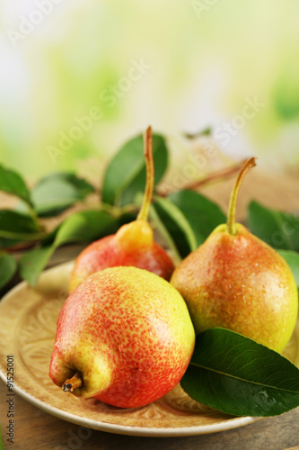 Fresh pears on wooden table on blurred background