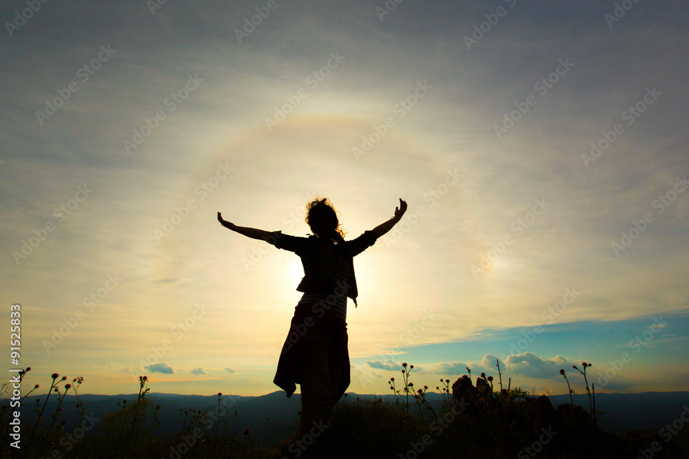 Young women joyfully jumping with sunbow in background Young women joyfully jumping with sunbow in background