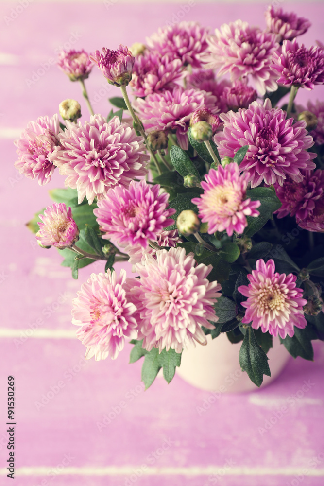 Obraz premium Beautiful purple chrysanthemum flowers on wooden table, closeup