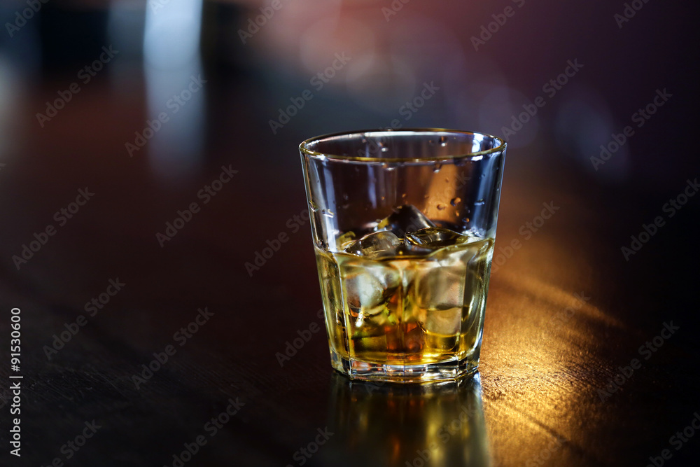 Whiskey glass tumbler standing on bar counter