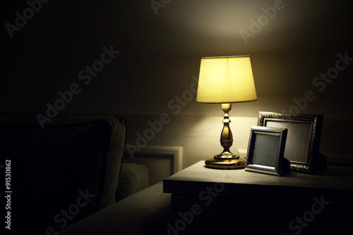 Old fashion table lamp on nightstand on wall background