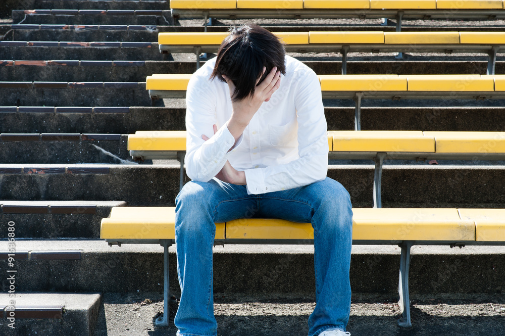 応援席で頭を抱える男性 応援席で頭を抱える男性