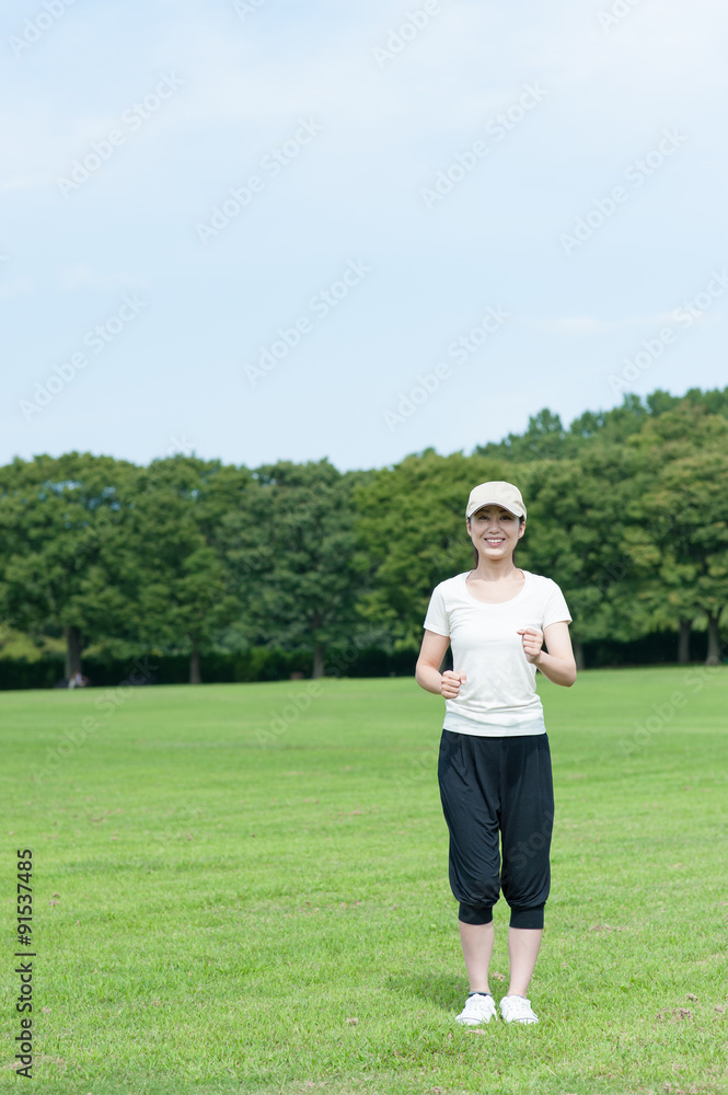 芝生の上を歩く女性