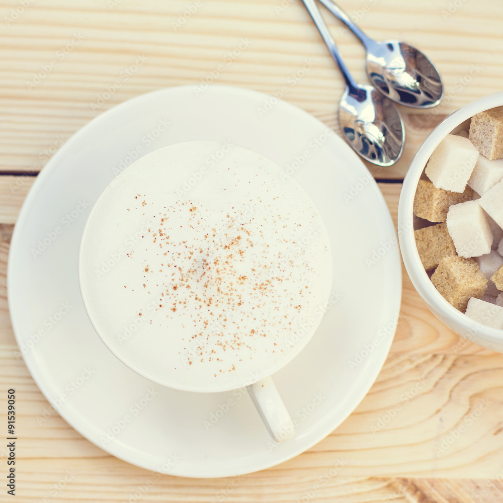 Classic foamy cappuccino in on a  wood table. Detail. From above.