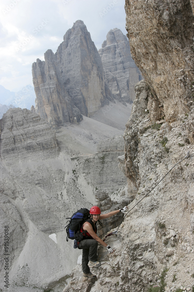 Frau am Klettersteig auf den Paternkofel, Sextener Dolomiten, im Hintergrund die Drei Zinnen