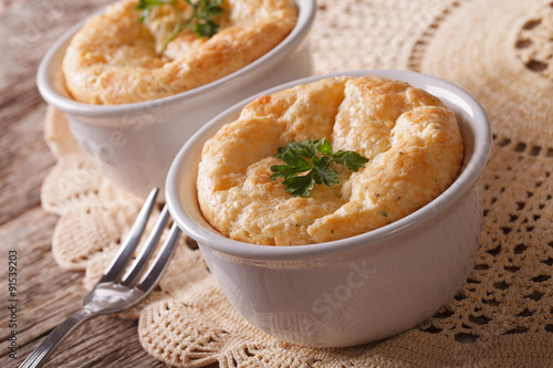 Two baked cheese souffle in a white pot close-up. horizontal
