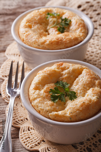 Two baked cheese souffle in a white pot close-up. vertical 