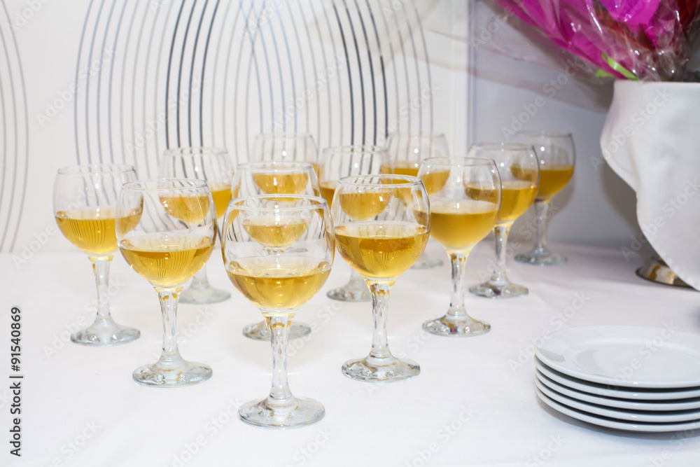 Glasses of wine on the table. The table decorations. The white tablecloth. Plates and white wine. The Banquet, serving. Party in the restaurant. Glasses of wine on the table. The table decorations. The white tablecloth. Plates and white wine. The Banquet, serving. Party in the restaurant.