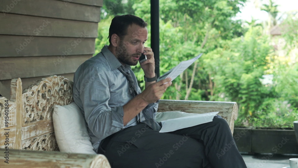 Angry businessman with documents talking on cellphone sitting on sofa on terrace
Angry businessman with documents talking on cellphone sitting on sofa on terrace