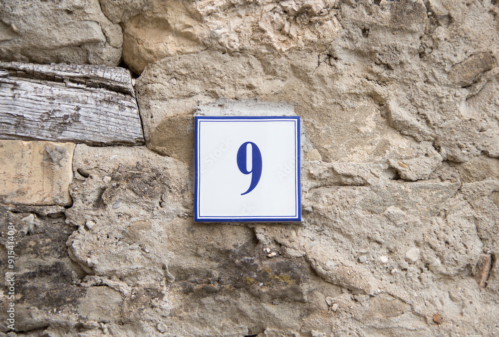 Number nine on the grey stone wall Number nine on the grey stone wall