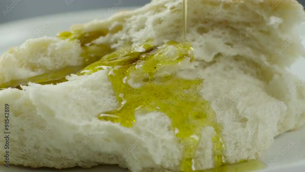 Pouring Olive Oil onto White Bread Pouring Olive Oil onto White Bread