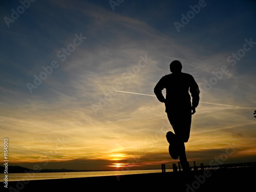 Fototapeta Naklejka Na Ścianę i Meble -  silhouette of a jogger in sunrise