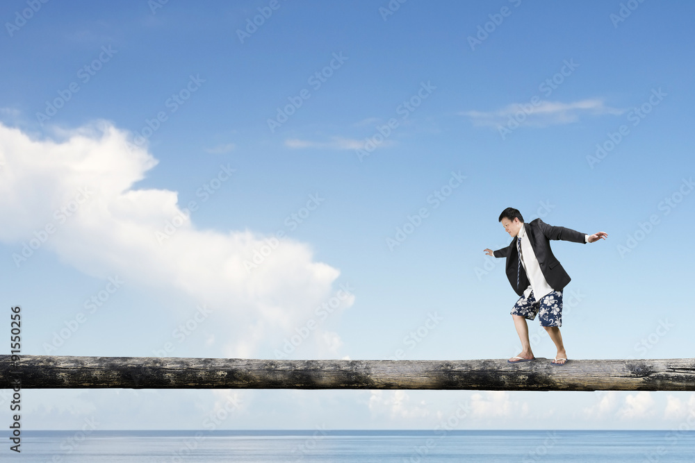 Man balancing on tree trunk high in the sky Man balancing on tree trunk high in the sky