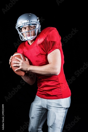 Determined American football player holding ball