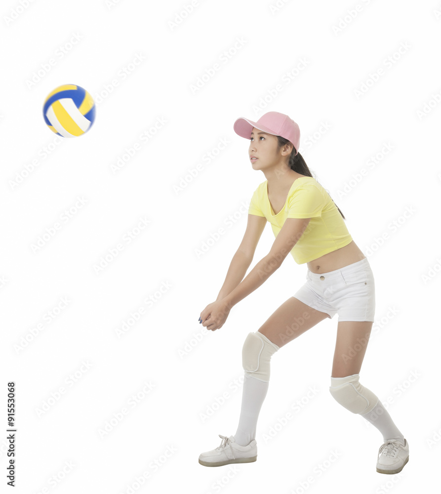 Asian teenage girl hitting a volleyball isolated on a white background