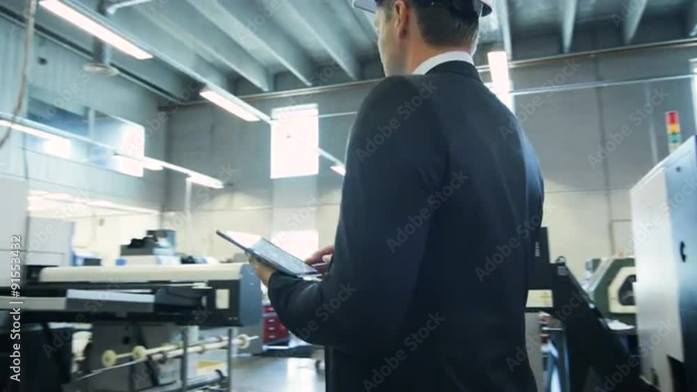 Businessman is Using Tablet PC in Industrial Environment Businessman is Using Tablet PC in Industrial Environment