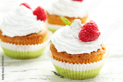 Raspberry cupcakes on white wooden background